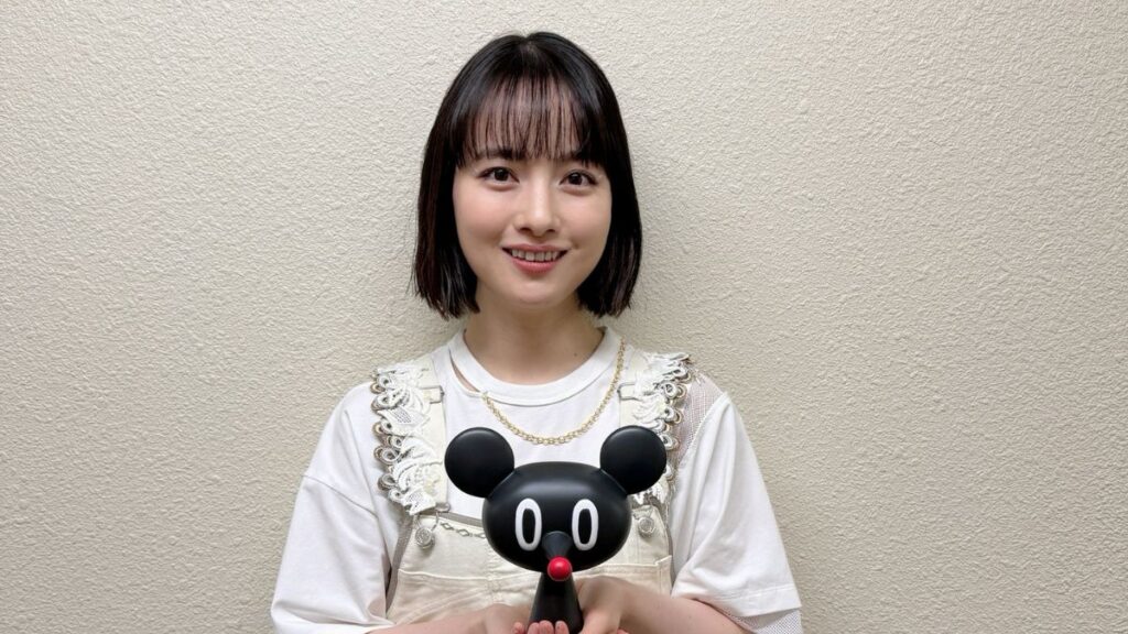 黒いねずみのような人形を持っているtomoo